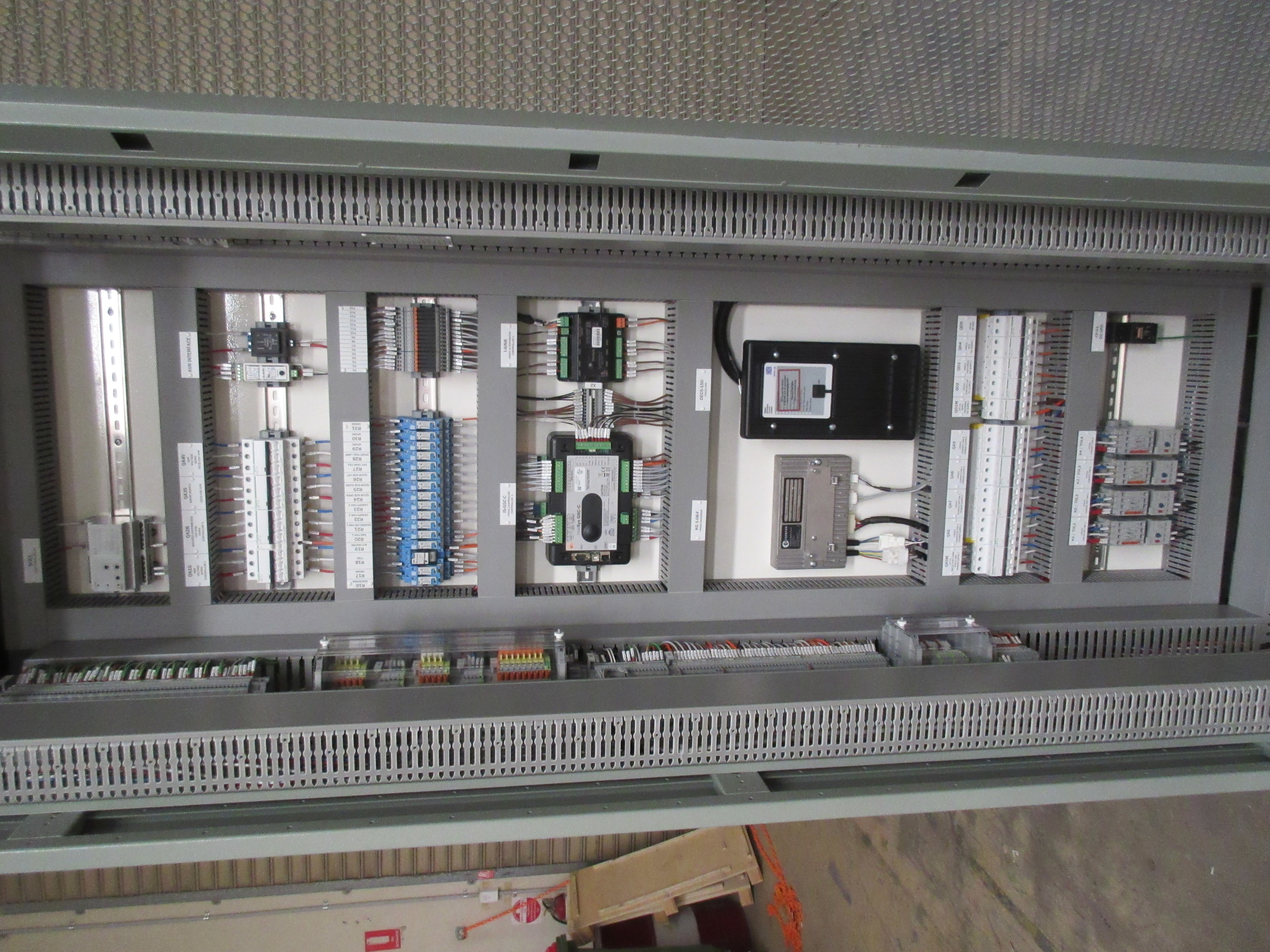 Interior of OEM control panel showing DIN rail wiring, terminal blocks, and PLC modules